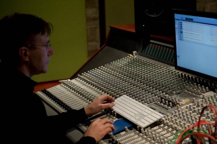 A guy sitting in front of the mixing console